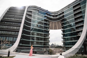 A modern building with a curved facade and multiple balconies.