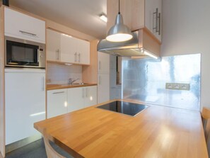 Een koelkast, een microgolfoven, een vaatwasser, een kinderstoel