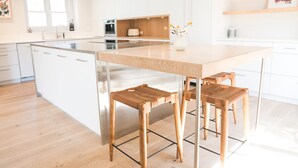A modern kitchen with a central island, stainless steel appliances, and wooden stools. - Gorgeous High-End Townhome - Easy Walk to Pearl Street, Campus, Google (Boulder)