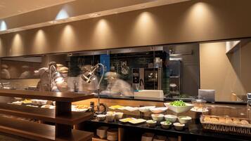 A buffet setup with various food items and a glass display case.