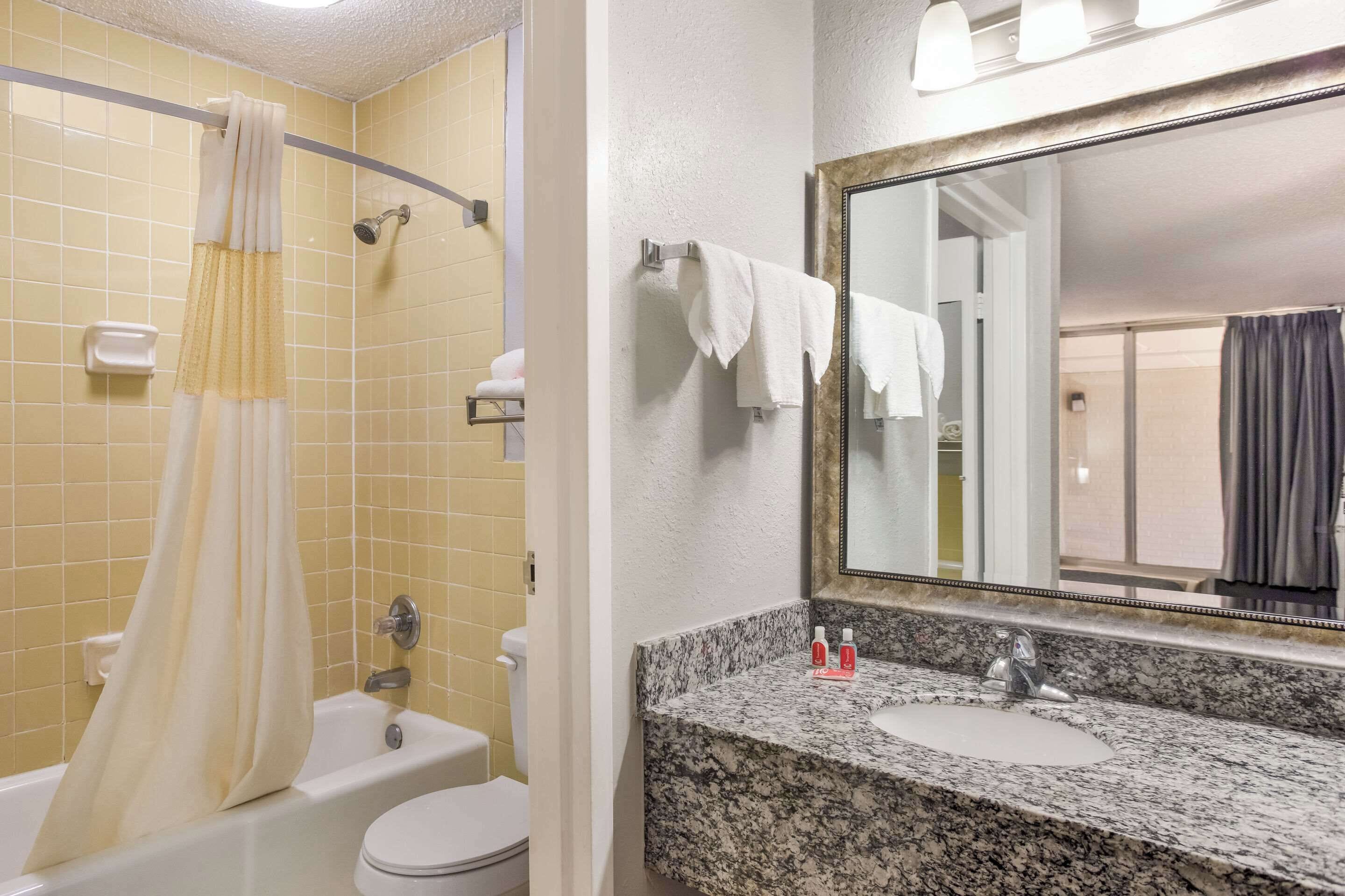 Ein Badezimmer mit Badewanne, Toilette und Waschbecken mit einer Granittheke.