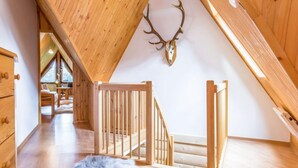A wooden interior with a sloped ceiling, a deer skull decoration, and a staircase. - Giewont View by Interhome (Zakopane)