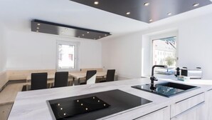 Una cocina moderna con una isla central, horno empotrado y una ventana que ofrece vistas de la ciudad.