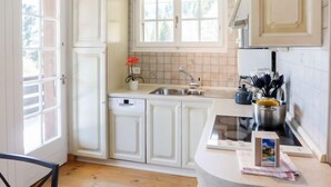 Una cocina moderna con armarios blancos, horno integrado y una ventana sobre el fregadero.