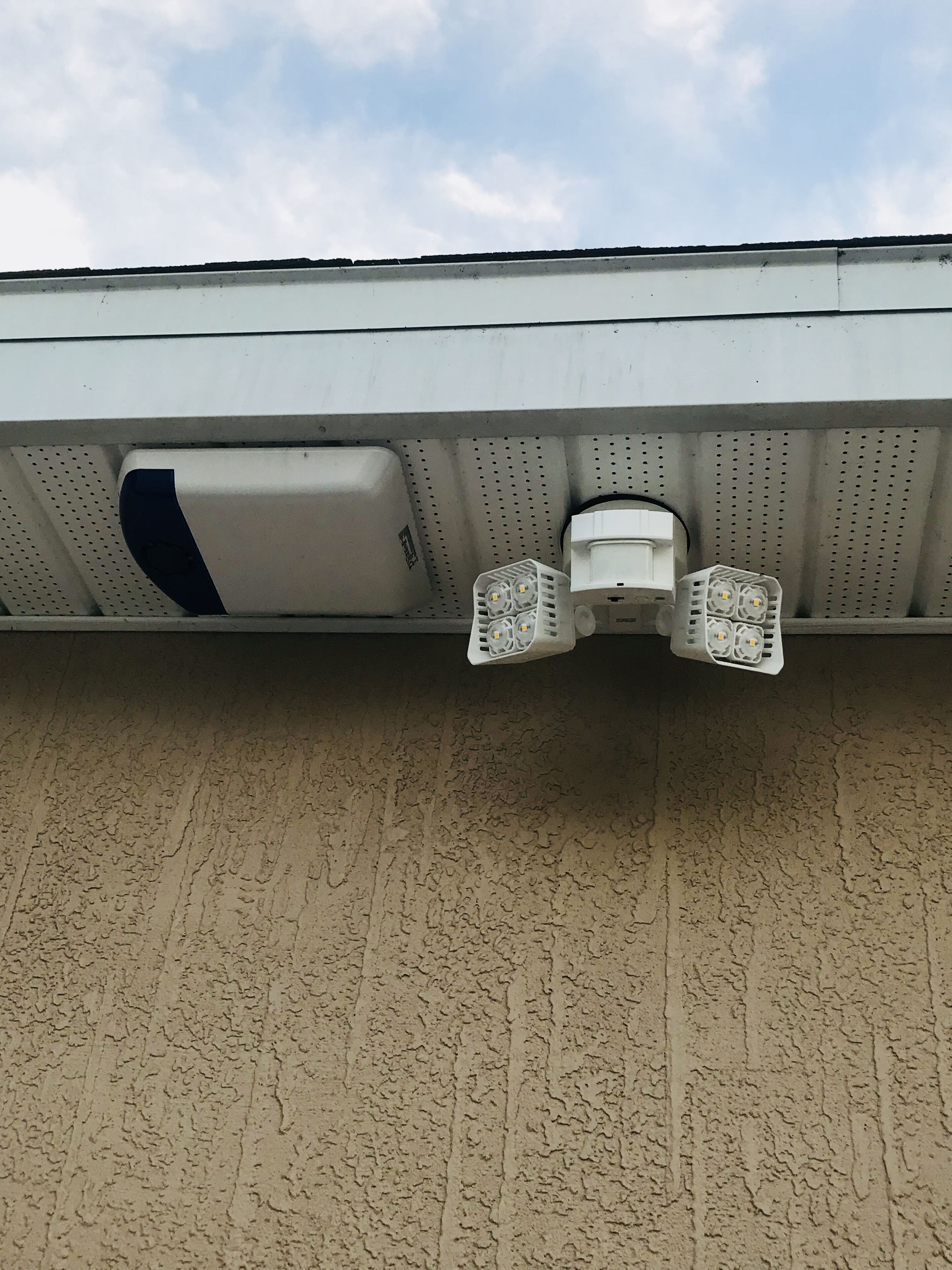 Un soffitto con una bocchetta di ventilazione bianca e due lampade bianche.