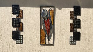 Een gevel met decoratieve muurkunst en een beveiligingsbord.