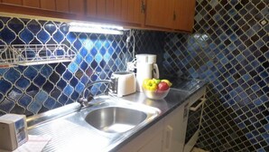 A kitchen with a stainless steel sink, a toaster, a coffee maker, and a bowl of fruit on the counter. - Le Mont Blanc 8 by Interhome (Villars)