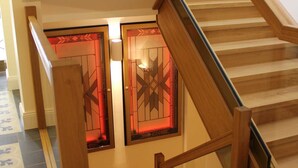 Una escalera de madera con paneles de vidrio y un suelo estampado.