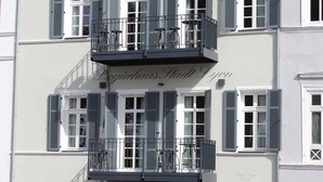 Un edificio de varios pisos con balcones, una escalera y un letrero que dice "Logierhaus Stadt Lyon".