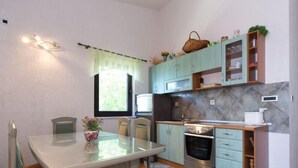 Une cuisine compacte dotée d’un îlot central, d’un four encastré et d’un four à micro-ondes.