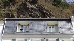 Un edificio de dos pisos con un balcón y un techo muy inclinado.