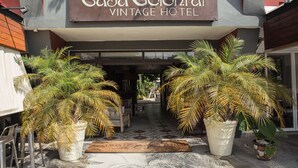 La entrada del Hotel Casa Colonial Vintage, con un letrero sobre la puerta y grandes macetas con plantas al frente.
