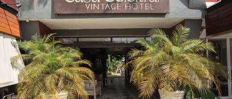 La entrada del Hotel Casa Colonial Vintage, con un letrero sobre la puerta y grandes macetas con plantas al frente.