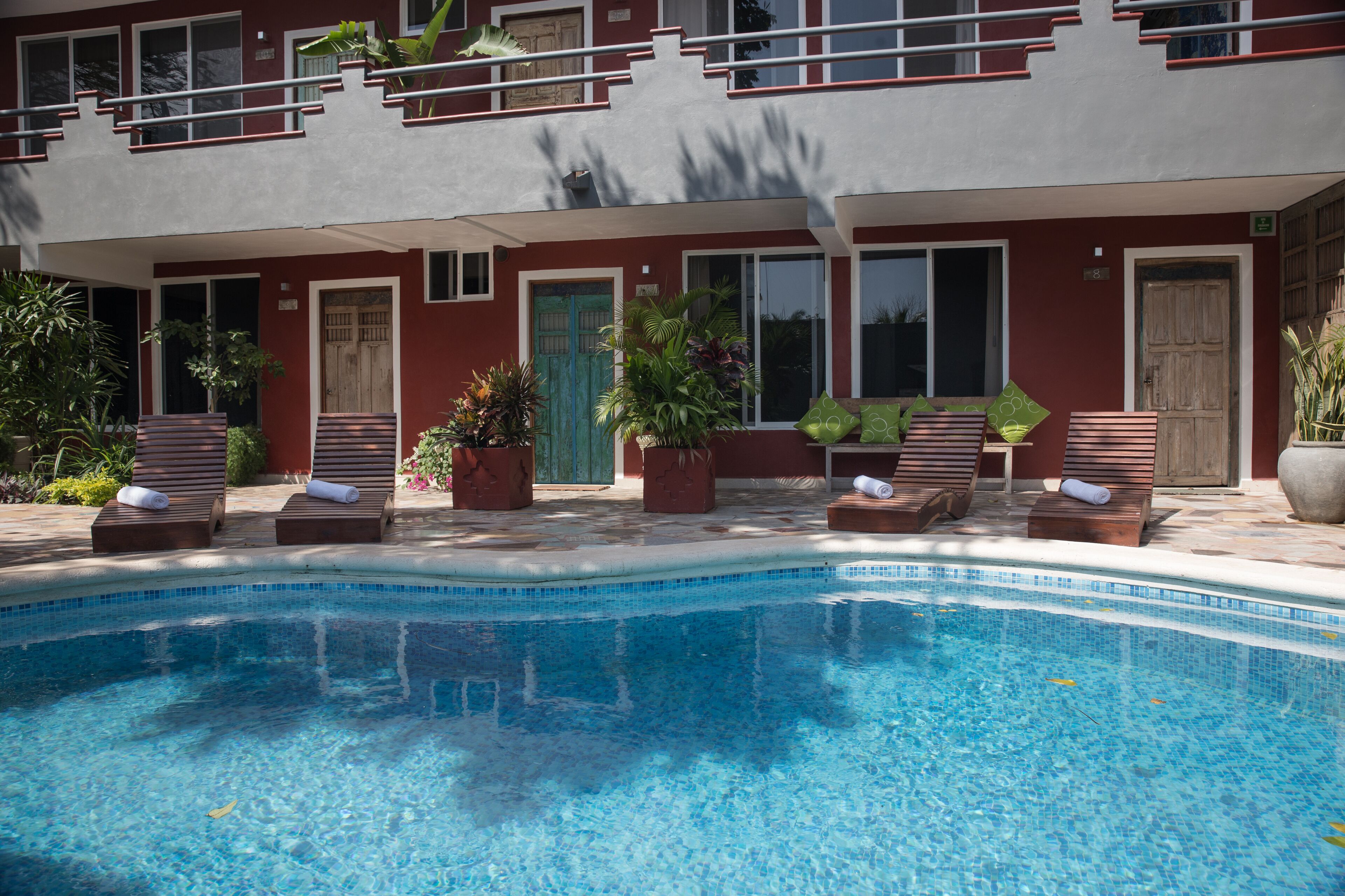 A poolside area with lounge chairs and potted plants.