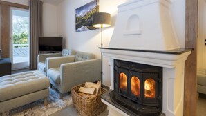 Un salon chaleureux avec une cheminée, un canapé, un téléviseur et un tableau accroché au mur.