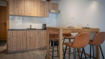 Une cuisine avec des meubles de rangement en bois, un plan de travail et un coin repas équipé de tabourets.