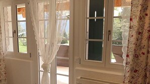 Una camera da letto con un letto, un termosifone e una finestra con tende.