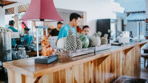 A wooden counter with a red lamp, various fruits, and a decorative pineapple. - Villa Casablanca Surf Keramas (Gianyar)