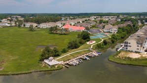 An aerial view of a residential area with houses, a dock, and a swimming pool. - 36 Old Mill Way, Bayside at Bethany Lakes - 4 Bedroom Luxury w/Community Pool (Ocean View)