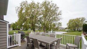 A deck with a dining table and chairs, surrounded by a white railing. - 36 Old Mill Way, Bayside at Bethany Lakes - 4 Bedroom Luxury w/Community Pool (Ocean View)
