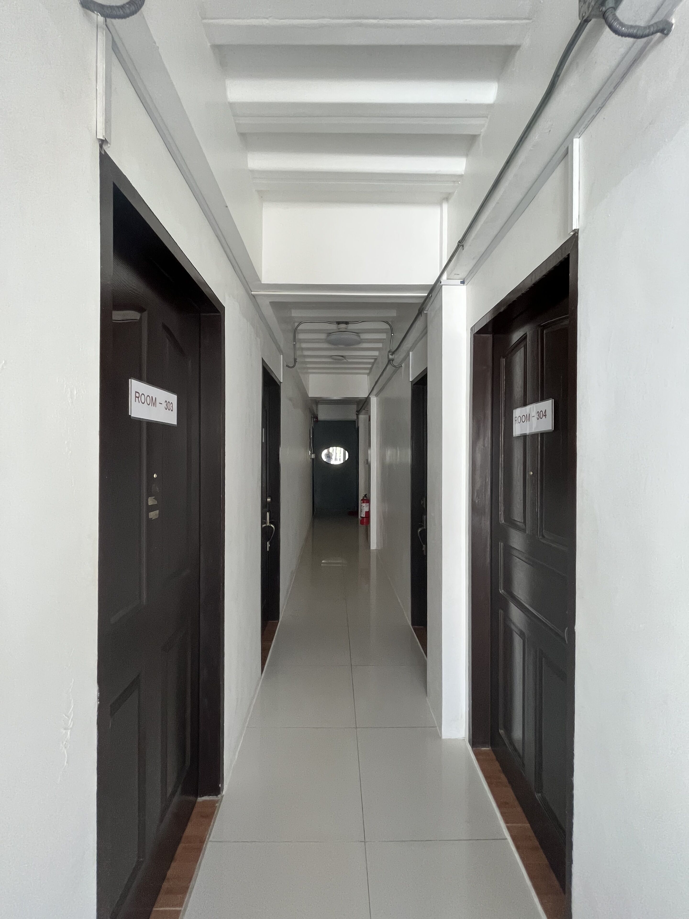 A corridor with doors labeled "ROOM - 303" and "ROOM - 304" in a hotel.