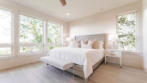 Un dormitorio con cama, mesitas de noche y un banco.