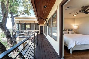 Une chambre avec un lit, un ventilateur de plafond et une vue sur l’extérieur.