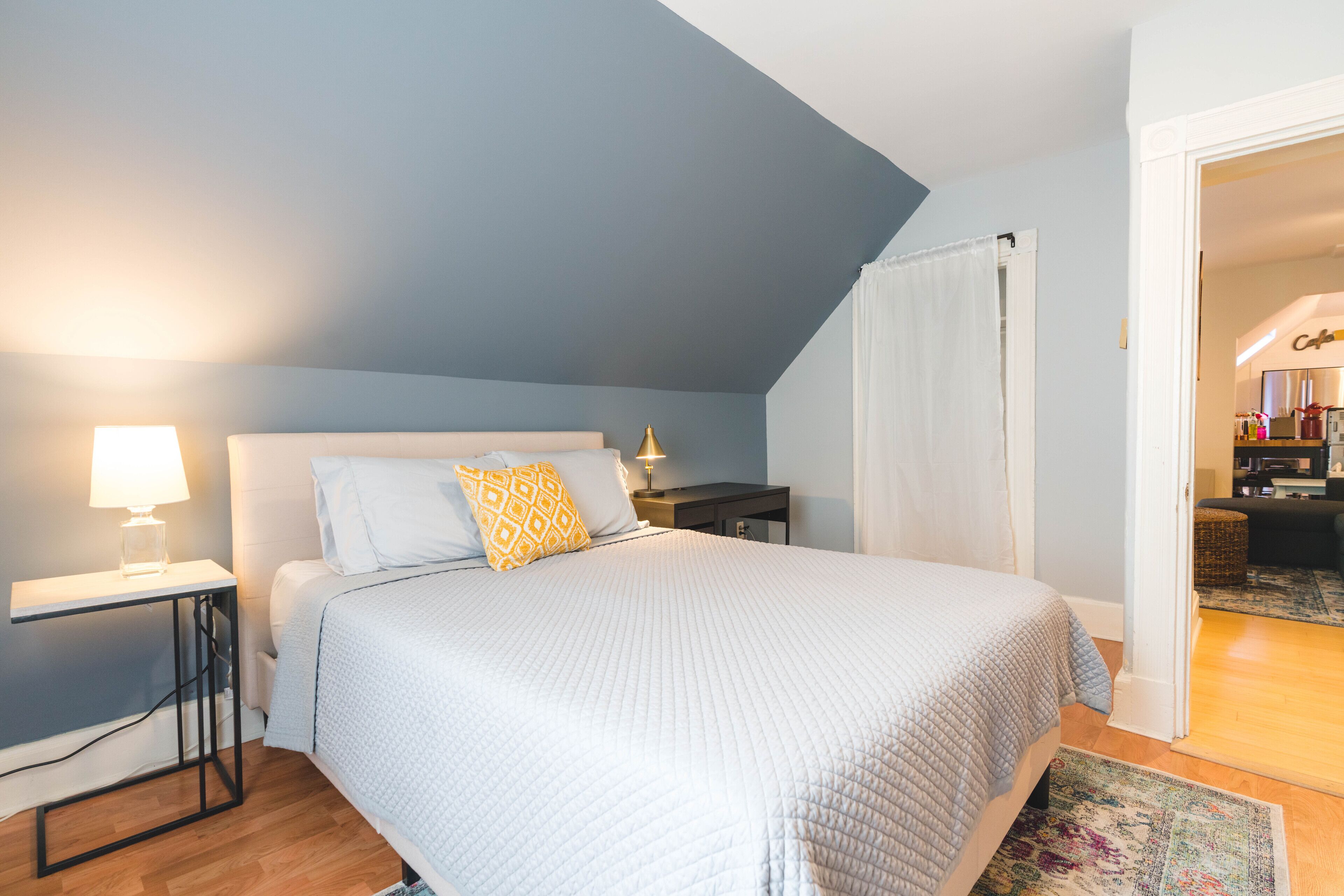Un dormitorio con cama, mesitas de noche y mesilla.