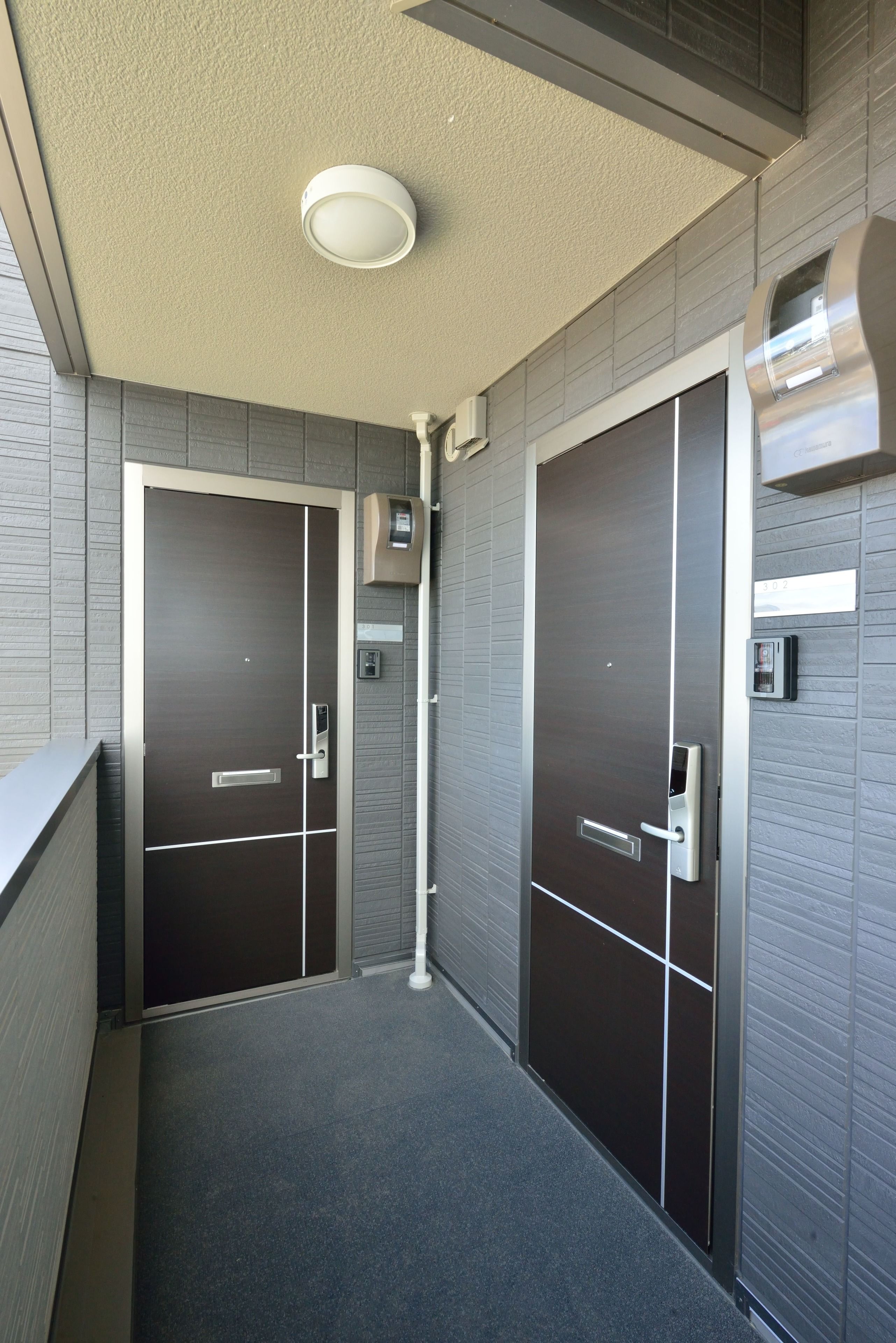 A hallway with two doors, each equipped with a card reader and a keypad.