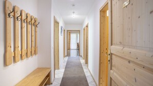 A hallway with wooden benches, coat hooks, and a bench with a plaque. - Ferienhof Sonnseitn by Interhome (Kaltenbach)