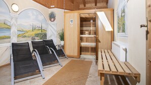 A sauna room with wooden benches, a massage table, and a wooden cabinet. - Ferienhof Sonnseitn by Interhome (Kaltenbach)