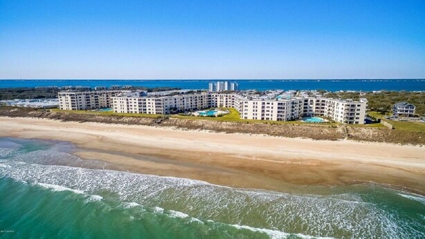 A beachfront hotel with multiple buildings, a sandy beach, and the ocean. - Panoramic View DIRECT OCEANFRONT Unit at Summer Winds. Multiple pools, hot tubs (Indian Beach)