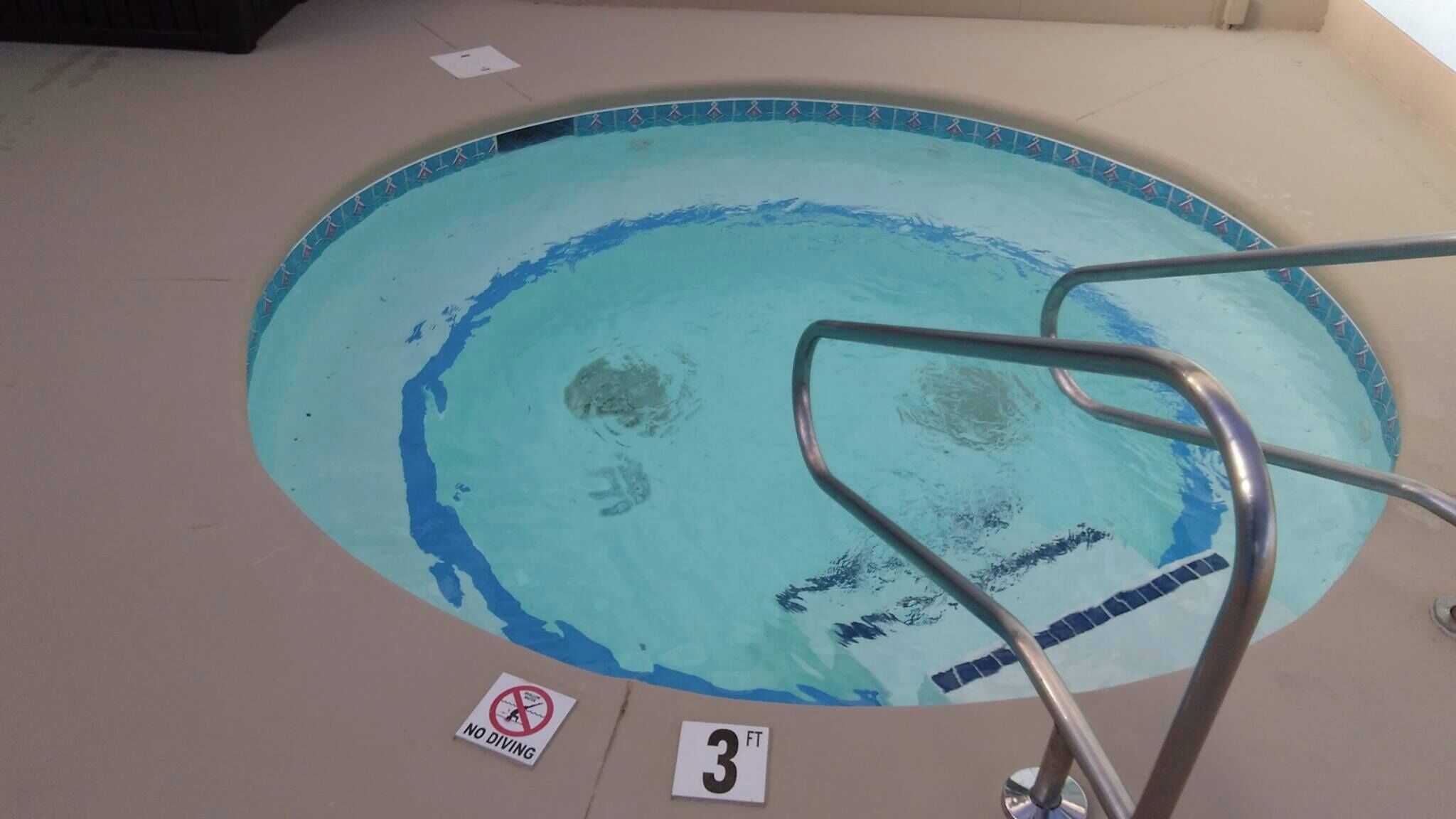 Ein Schwimmbecken mit einem Schild, das 'KEIN TAUCHEN' besagt, und einer Tiefenmarkierung für 3 Fuß.