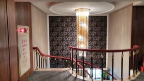 A staircase with a red handrail and a patterned wall in the background. - Kai Wei Boutique Hotel (Taipei)