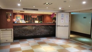 A reception area with a check-in counter, a refrigerator, and a tiled floor. - Kai Wei Boutique Hotel (Taipei)