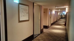 A hotel hallway with carpeted floors, framed architectural drawings on the walls, and doors leading to rooms. - Kai Wei Boutique Hotel (Taipei)
