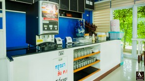 A modern reception area with a coffee machine, a cash register, and a counter with various items. - The Areaac (Hang Chat)