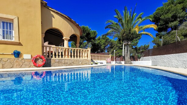 A clear blue pool with tiled flooring, a lifebuoy, and a palm tree. - 0302 Villa Monte Verde Pera (Javea / Xàbia)