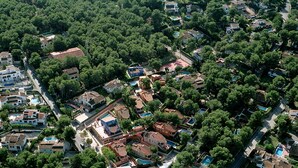 An aerial view of a residential area with houses, trees, and a road. - 0302 Villa Monte Verde Pera (Javea / Xàbia)
