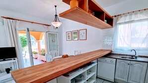 A kitchen with a wooden countertop, white cabinets, a dishwasher, and a window with curtains. - 0314 Villa Monte Verde Cereza (Javea / Xàbia)
