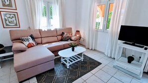A modern living room with a sofa, a coffee table, a TV, and a patterned rug. - 0314 Villa Monte Verde Cereza (Javea / Xàbia)