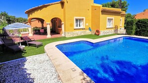 A yellow villa with a swimming pool, outdoor seating, and a patio area. - 0314 Villa Monte Verde Cereza (Javea / Xàbia)