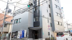 A multi-story building with a modern design, featuring a prominent entrance with a glass door and a visible signboard. - nid NIPPONBASHI at Ebisu (Osaka)