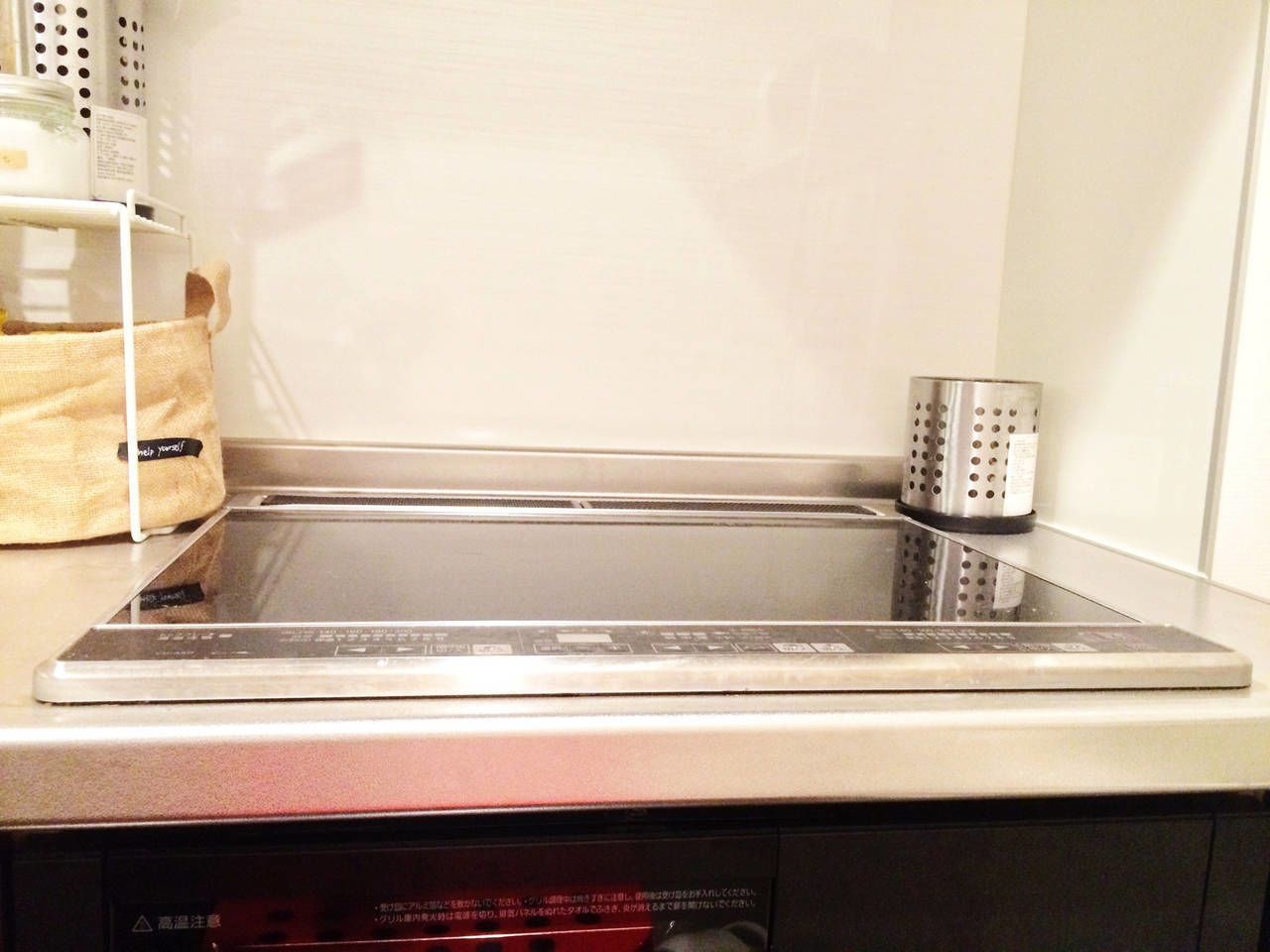 Een keuken met een rvs inductiekookplaat, een rvs waterkoker en een afwassysteem.