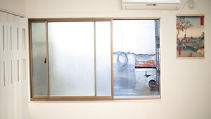 Una stanza con un'ampia porta-finestra in vetro, un termosifone e un quadro appeso al muro.