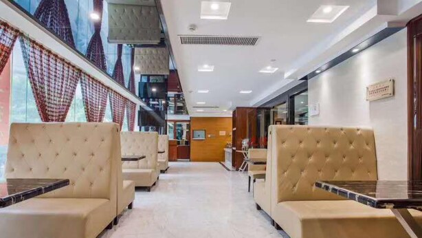 Un hall de hotel con asientos cómodos, una recepción central y vistas a través de amplios ventanales.