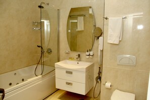 A modern bathroom with a glass-enclosed shower, a white vanity with a mirror, and a toilet.