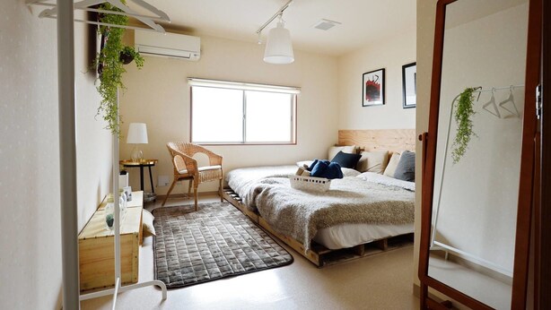A compact bedroom with a bed, a chair, a desk, and a window. - nid Shimanouchi House (Osaka)