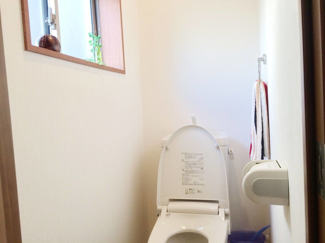 A bathroom with a toilet, a hand dryer, and a towel rack.