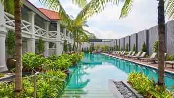 A pool area with lounge chairs and palm trees.